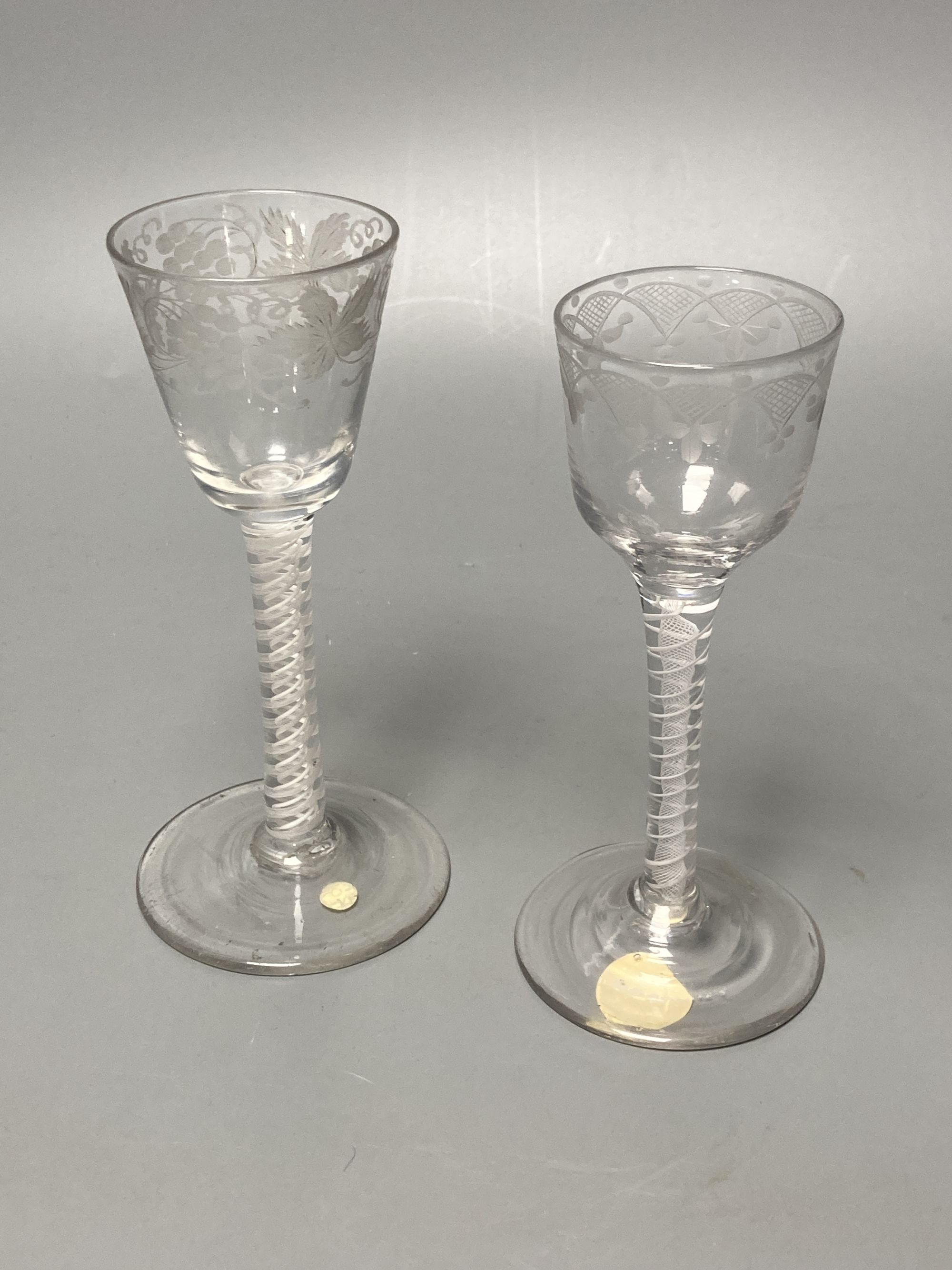 Two George III double series opaque twist stem cordial glasses, c.1760-70, with wheel engraved funnel and ogee bowls, 14.7cm and 14cm